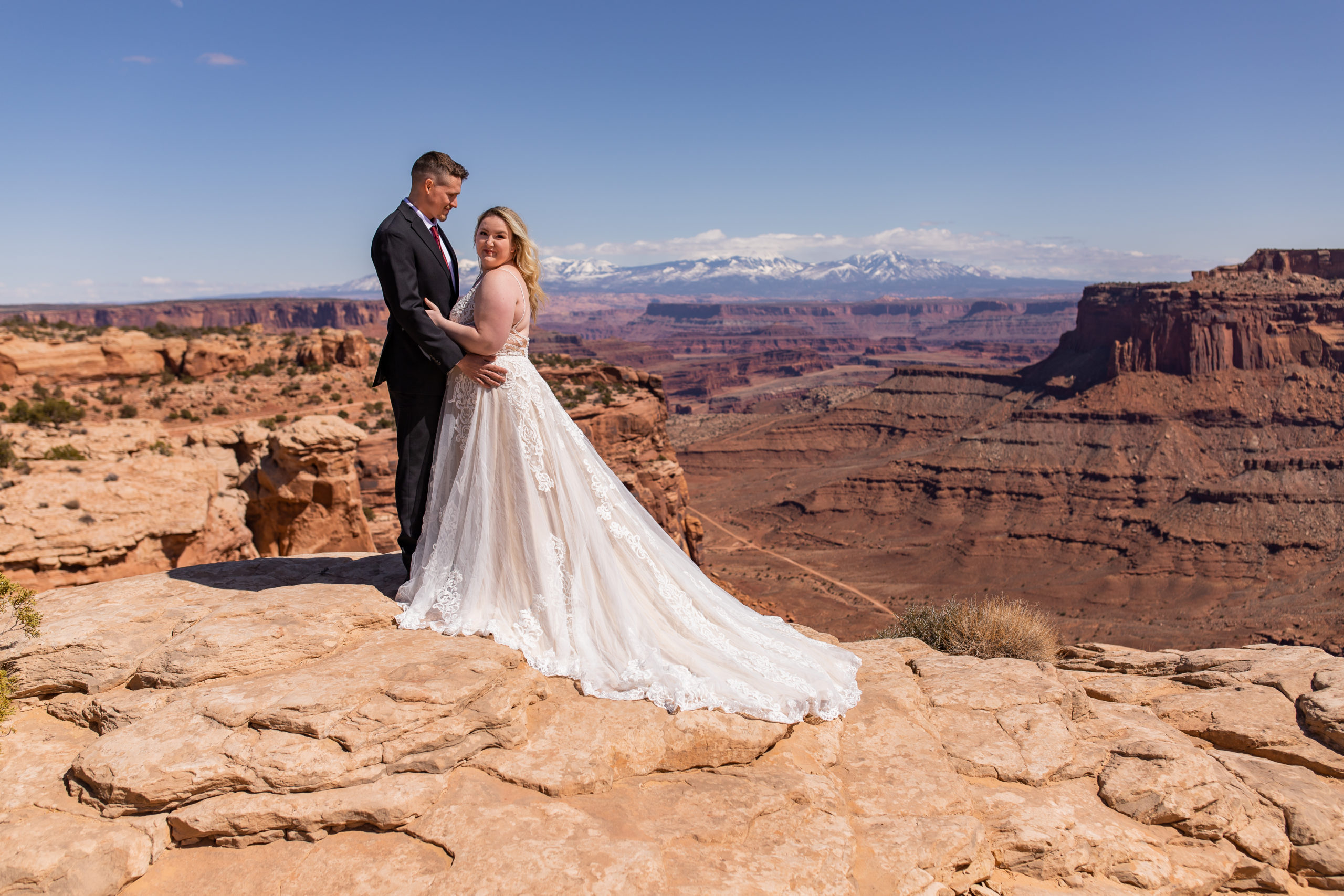 Bride and groom overlooking the canyon in Canyonlands National Park in Moab, Utah