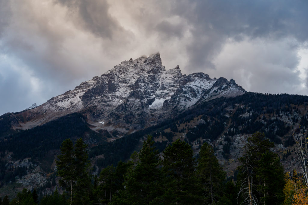 The Teton mountains with gloomy clouds hover over the peaks.