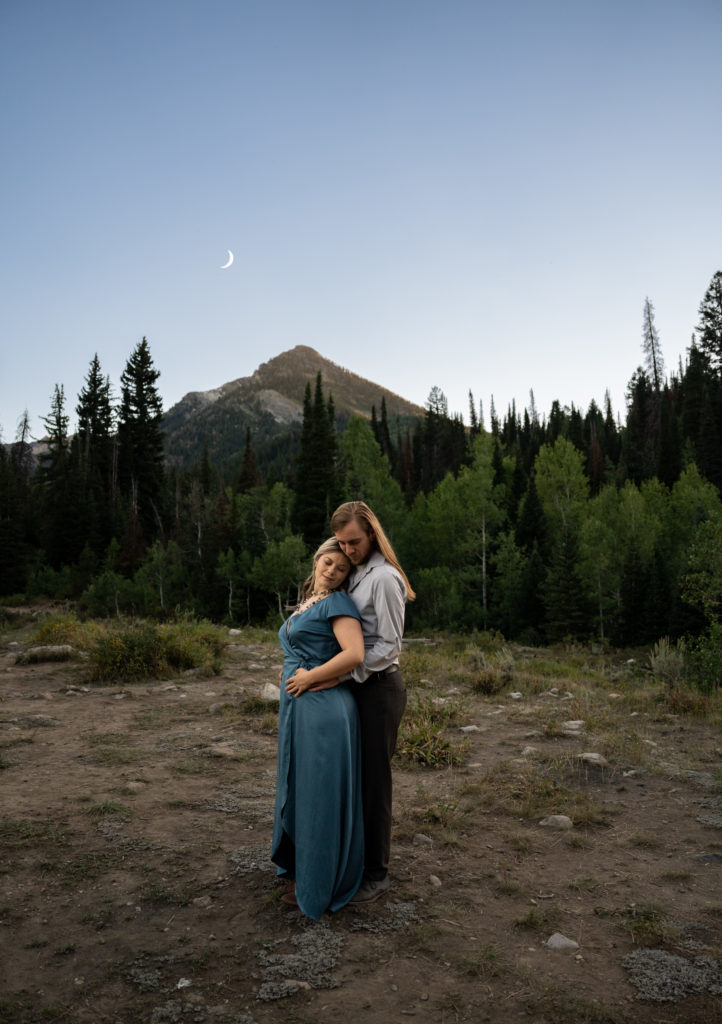Couple standing together in the mountains at blue hour in Big Cottonwood Canyon in Salt Lake City, Utah