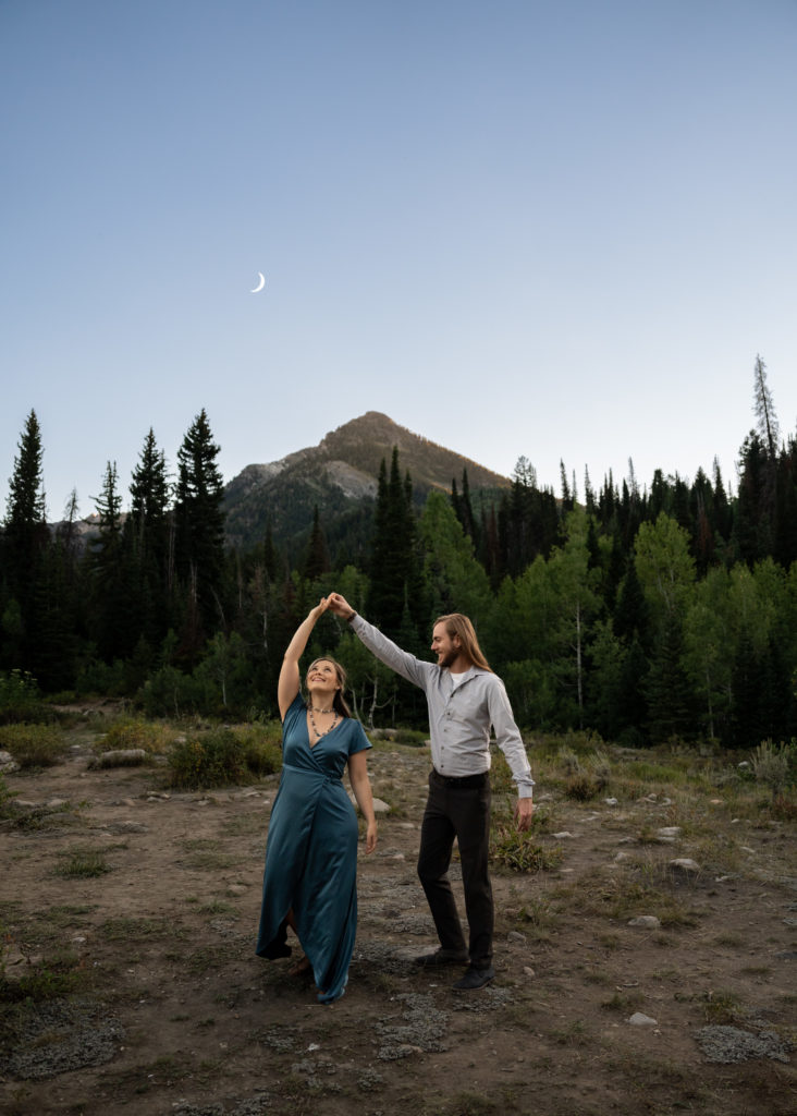 Couple dancing under the moon at blue hour in the mountains of Big Cottonwood Canyon in Salt Lake City, Utah