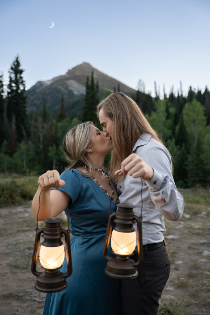 Couple kissing holding lanterns at blue hour in Big Cottonwood Canyon in Salt Lake City, Utah