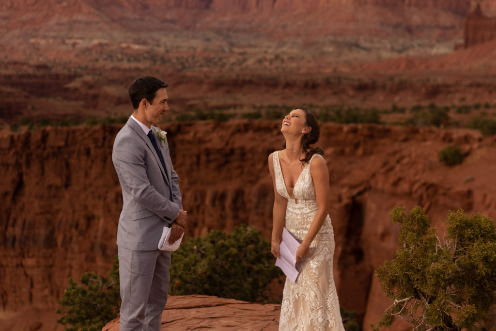 Bride and groom reading vows to each other on a cliffside in Capitol Reef National Park