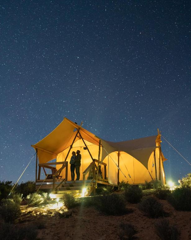 Luxurious canvas tent lit up at night under the stars at ULUM resort in Moab, Utah