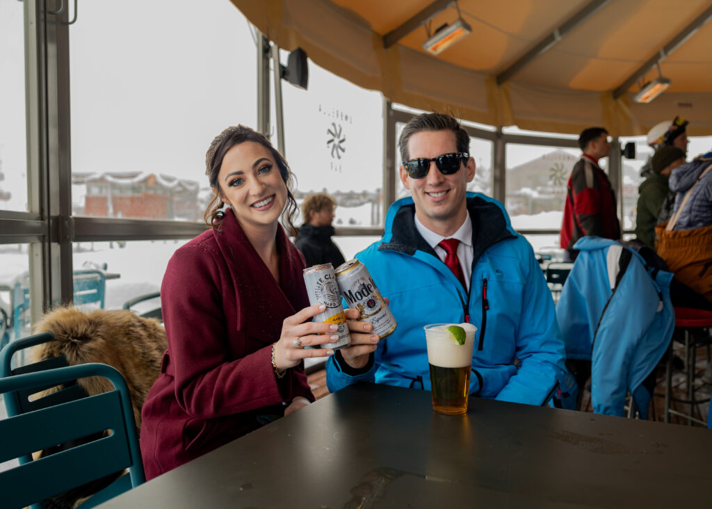 Bride and groom sitting in après ski bar with their drinks.