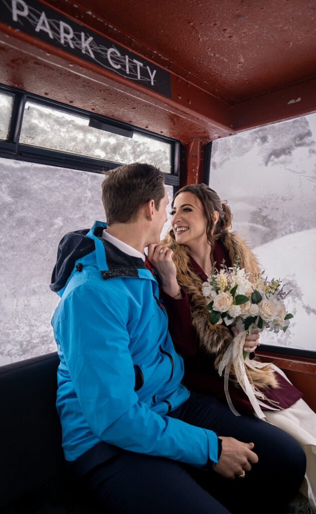 Bride and groom in a gondola going up the snowy mountain in Park City, Utah.