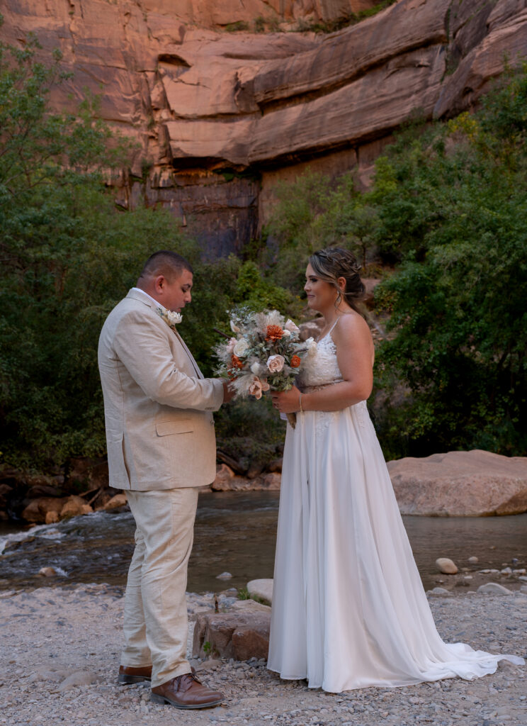 Bride and groom reading vows to each other at the Temple of Sinawava in Zion National Park in Utah