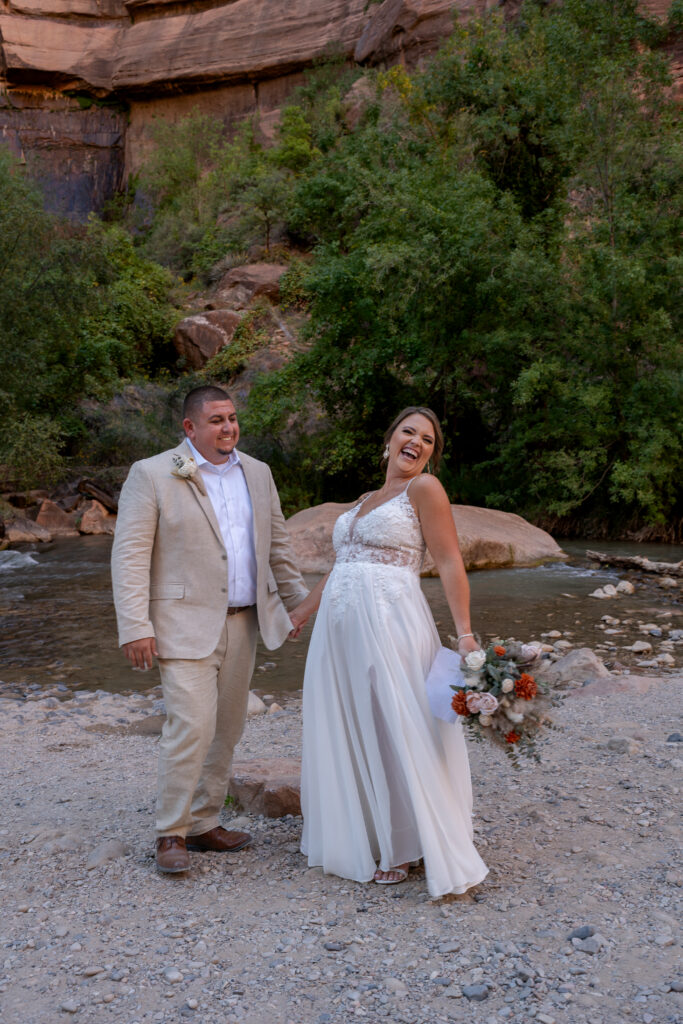 Bride and groom laughing at the Temple of Sinawava in Zion National Park in Utah