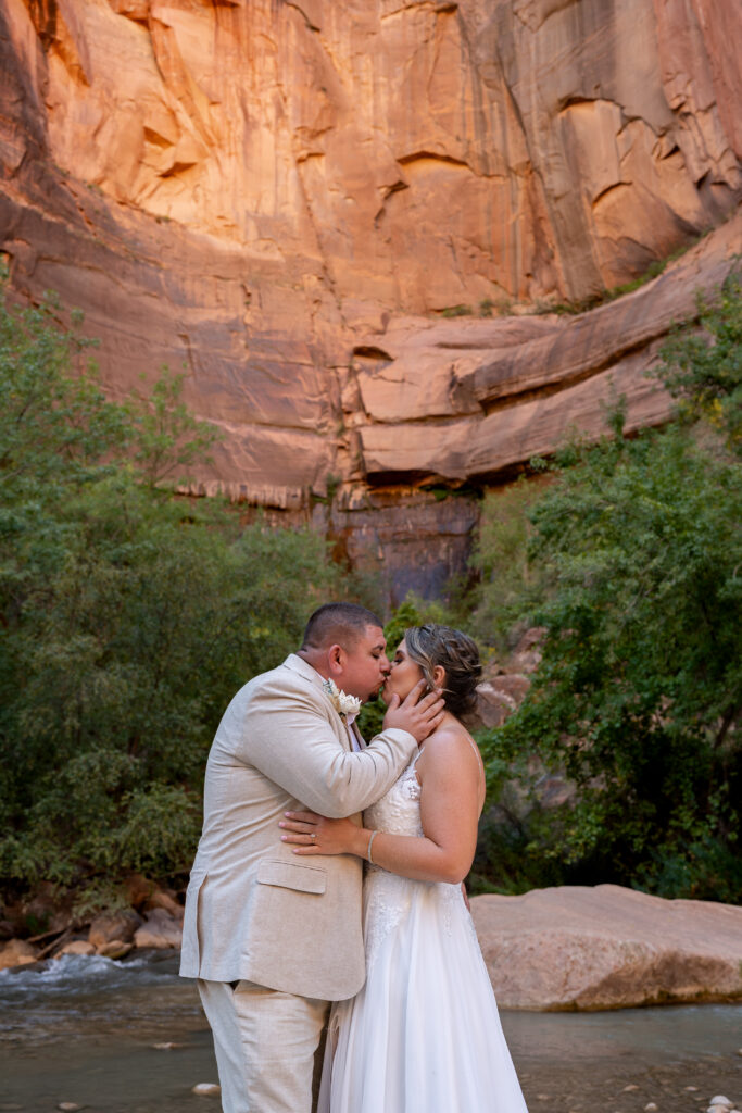 Bride and groom kissing at the Temple of Sinawava in Zion National Park in Utah