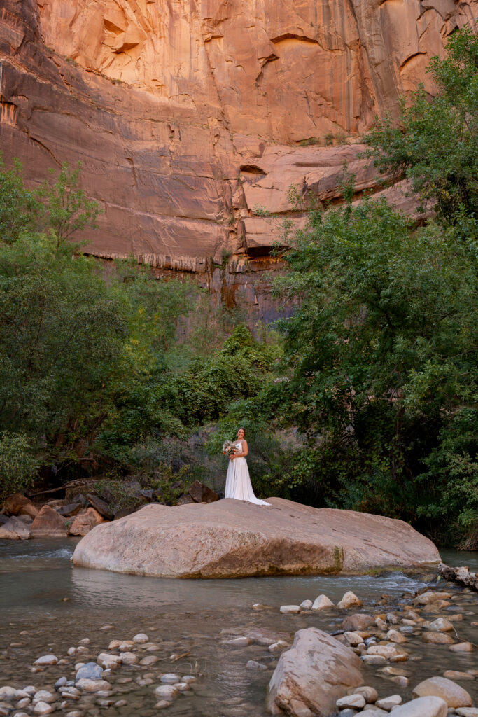 bride on a rock in the Virgin River in Zion National Park in Utah