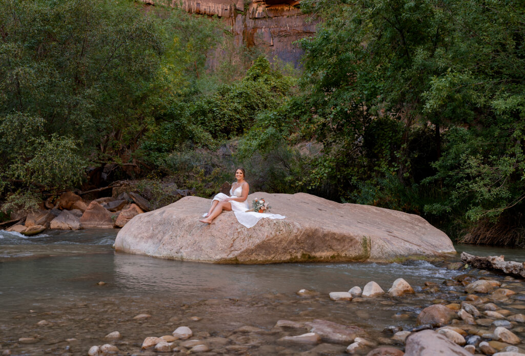 bride on a rock in the Virgin River in Zion National Park in Utah