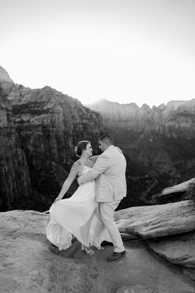 Bride and groom dancing with each other on a cliff in Zion National Park in Utah