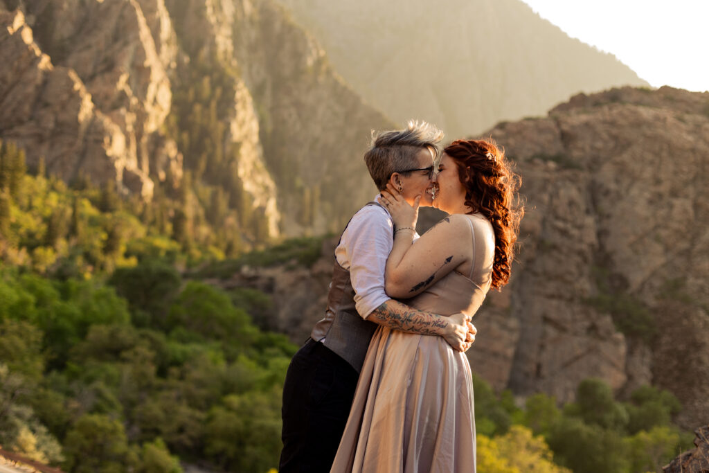 Two brides embracing in a kiss in the mountains of Salt Lake City, Utah