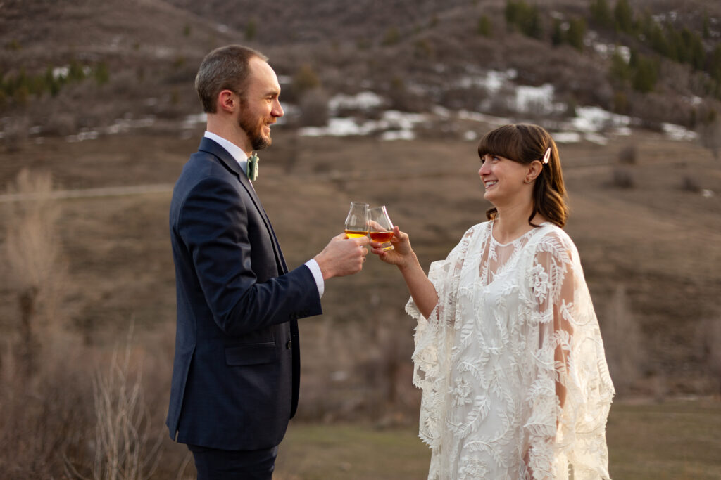 Bride and groom toasting with drinks in the mountains near Salt Lake City, Utah