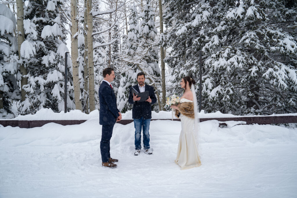 Eloping bride and groom with their officiant during their snowy mountain ceremony in Park City, Utah