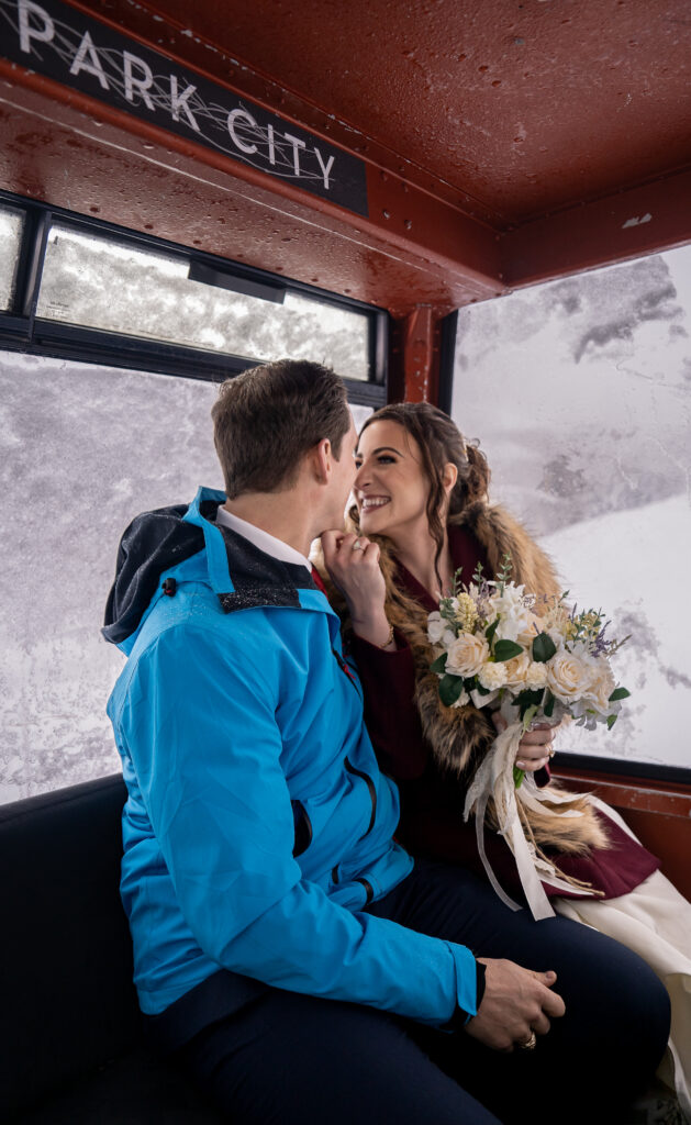 Eloping bride and groom riding a gondola up the snowy mountain in Park City, Utah